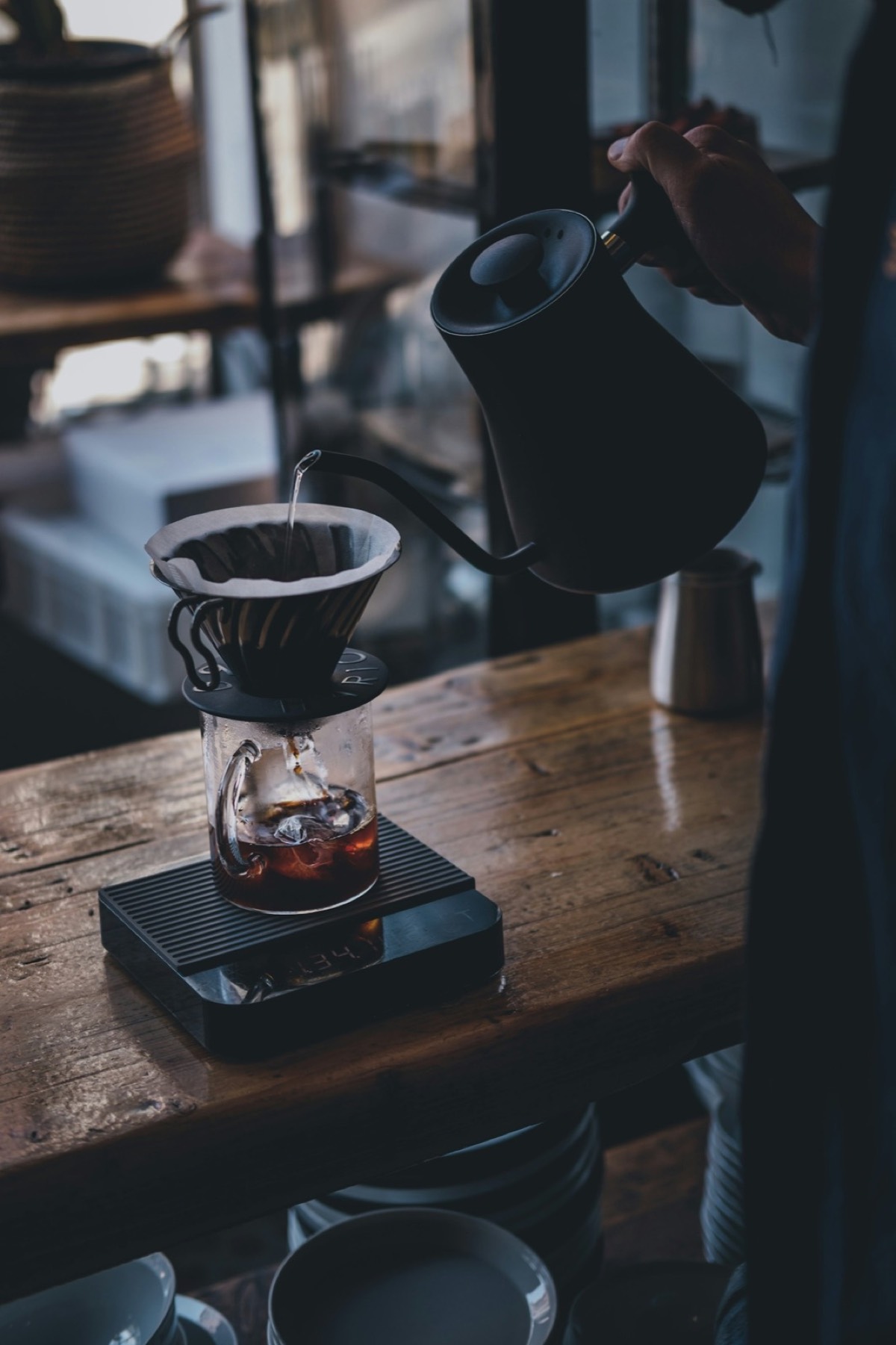 A black ceramic coffee mug on a wooden table.