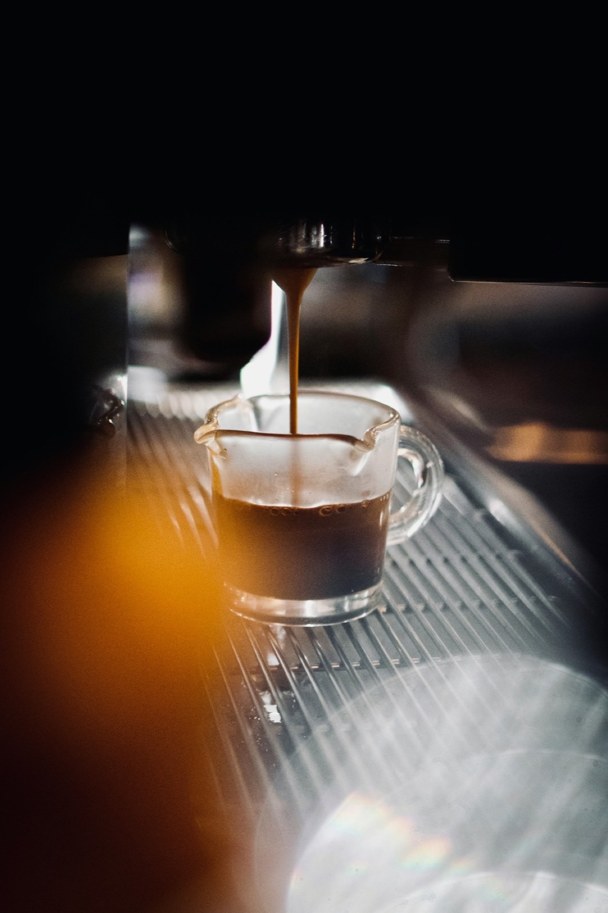 A clear glass mug filled with brewed coffee.