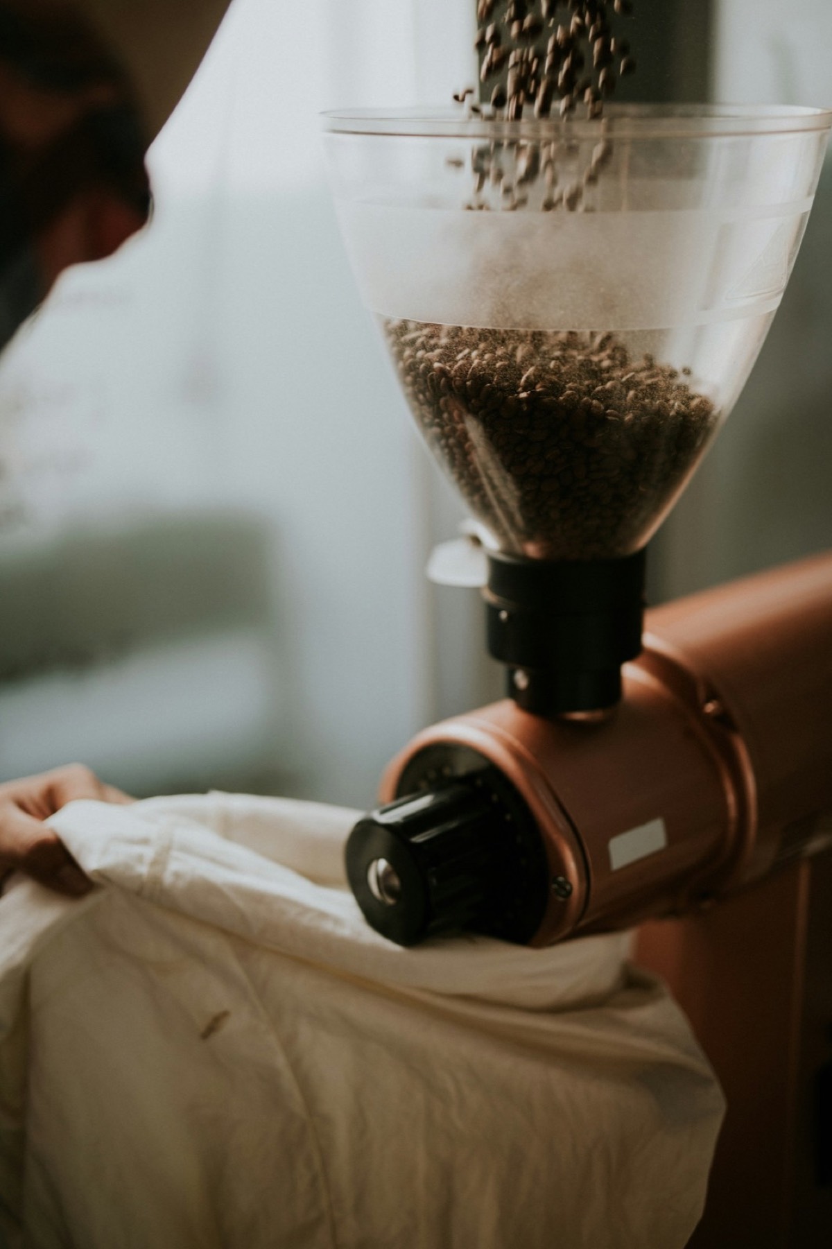 A person using a hand grinder for coffee.