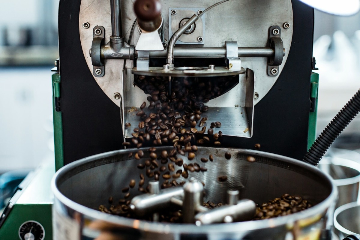 Coffee beans being ground in a grinder.